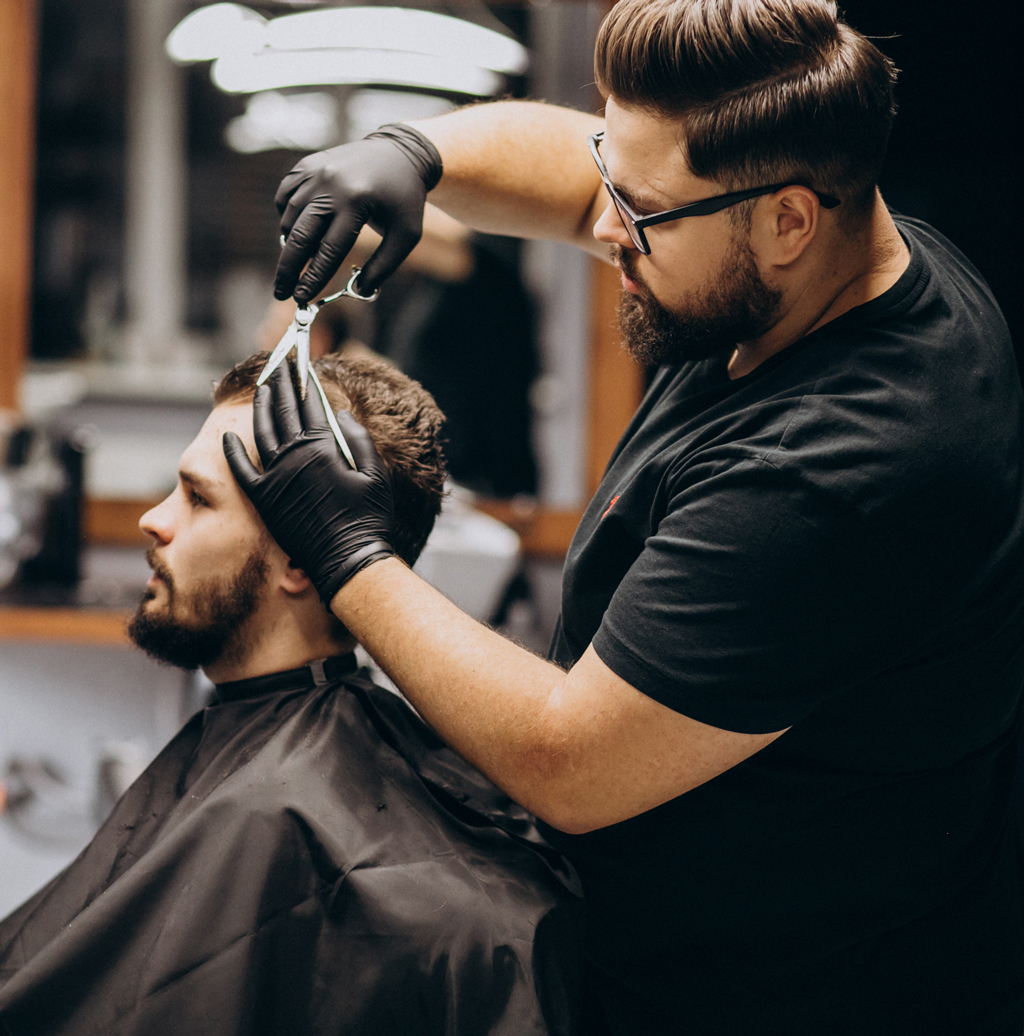 Man weave specialist performing hair unit installation at salon